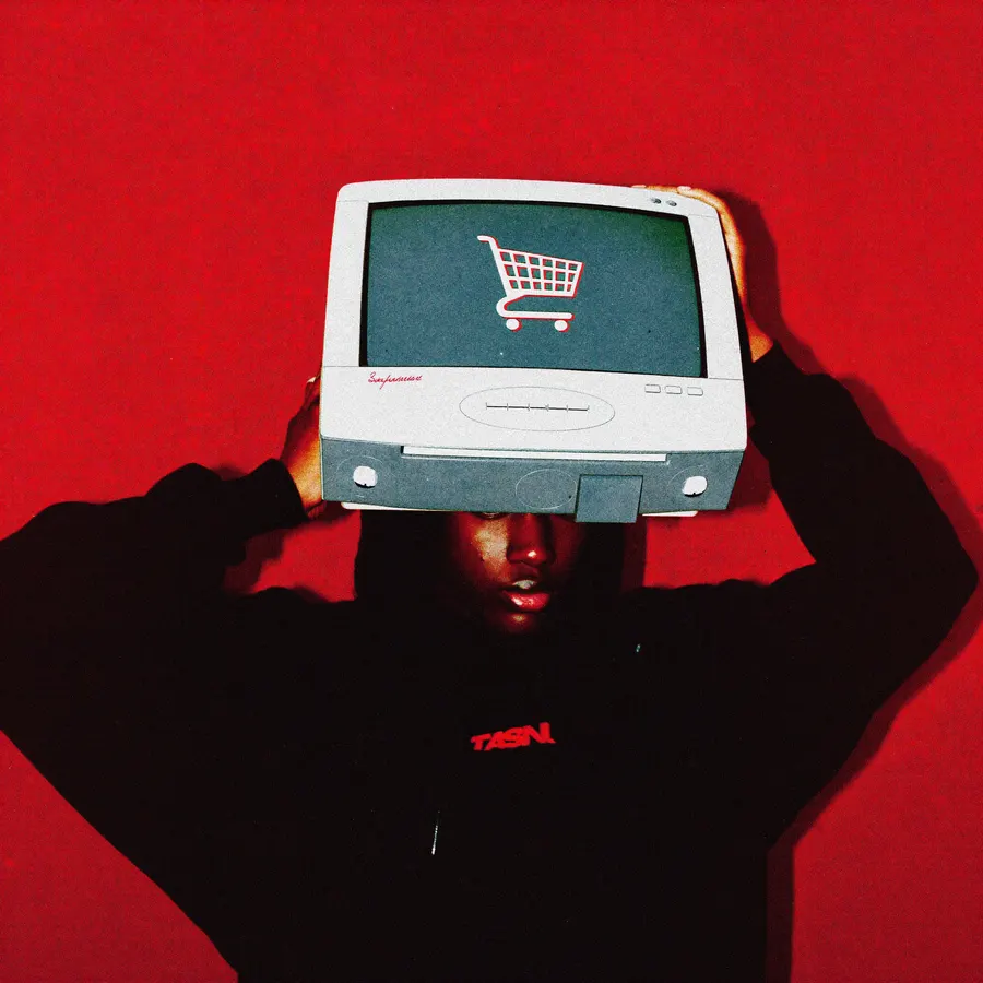 Editorial red-toned portrait of a creative holding a monitor showing a shopping cart icon